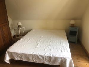 una camera con un letto bianco e due comodini di Ferienhaus Bretagne Pointe du Raz a Plogoff