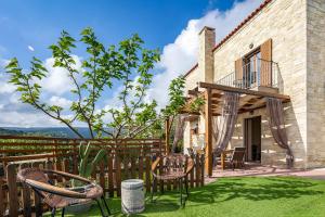 un patio con sillas y una valla de madera en Villa Erato Klio, en Kiriánna