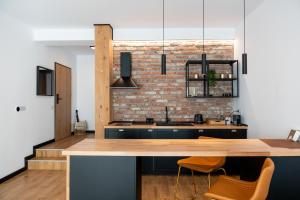 a kitchen with a wooden counter and a brick wall at Vila Ferdinand - Apartament Iarina in Sinaia