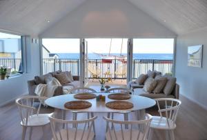 a living room with a table and chairs and the ocean at Penthouse over the harbour in Skillinge