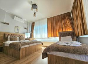 a bedroom with two beds and a large window at Grey House Apartments & Suites Istanbul in Istanbul +130 photos