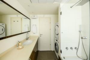 Chic 2BR Apt w Large Windows in Tel Aviv Old North في تل أبيب: حمام مع مغسلة وغسالة ملابس