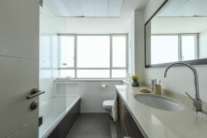 Chic 2BR Apt w Large Windows in Tel Aviv Old North في تل أبيب: حمام مع حوض وحوض استحمام ومرحاض