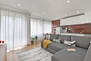 un salon avec un canapé gris et une cuisine dans l'établissement Apartamento Ponte D Luís, à Vila Nova de Gaia