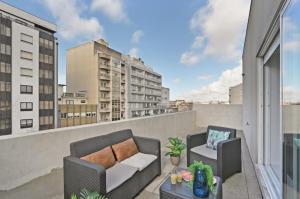 d'un balcon avec deux chaises et un canapé sur le toit. dans l'établissement Apartamento Ponte D Luís, à Vila Nova de Gaia