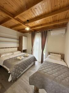a bedroom with two beds and a window at Vila Soleil in Vlorë