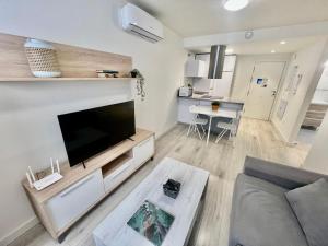 a living room with a large flat screen tv at Apartamentos Rincón del Mar in Torre del Mar