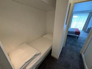 a small bedroom with a bed and a window at Grand studio sur le golf de Chiberta in Anglet