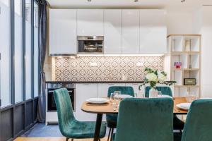 a kitchen and dining room with a table and chairs at Bridgestreet Le Marais - les halles - Republique in Paris