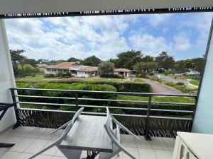 a balcony with two chairs and a view of a street at Grand studio sur le golf de Chiberta in Anglet +9 photos