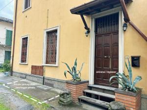 a house with a wooden door and two plants in front at Traveler's Retreat in Lecco in Lecco