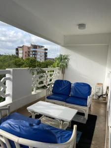 ein Balkon mit einer Couch und einem Tisch und Stühlen in der Unterkunft Nyali Sunrise Apartment in Nyali