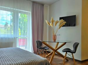 a bedroom with a table and two chairs and a window at TREND HOUSE Apartments in Vinnytsya
