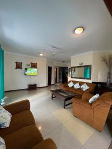 ein Wohnzimmer mit Sofas und einem Flachbildfernseher in der Unterkunft Nyali Sunrise Apartment in Nyali