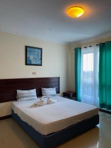 ein Schlafzimmer mit einem Bett, auf dem zwei Handtücher liegen in der Unterkunft Nyali Sunrise Apartment in Nyali + 10 Fotos