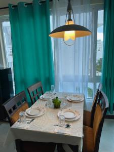 ein Esstisch mit einer weißen Tischdecke und einer Leuchte in der Unterkunft Nyali Sunrise Apartment in Nyali