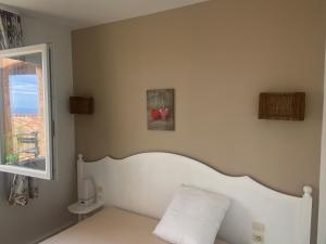 Un dormitorio con una cama blanca y una ventana. en Très bel appartement T3 avec splendide vue mer, en Les Issambres