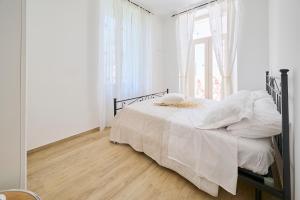 a bedroom with a bed with white sheets and a window at B&B VillaPrimavera in Porto San Giorgio