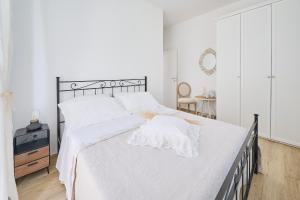 a bedroom with a large bed with white sheets at B&B VillaPrimavera in Porto San Giorgio