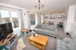 ホーニングにあるThe Boat House - Holiday Home in Horning on the Norfolk Broadsのソファとテレビのあるリビングルーム