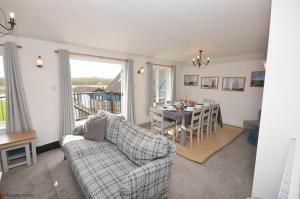 ホーニングにあるThe Boat House - Holiday Home in Horning on the Norfolk Broadsのソファとテーブルのあるリビングルーム