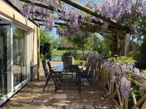 a patio with wisteria hanging from a pergola at Spacious Comfort Villa Vera with hottub in Zeewolde