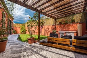a patio with a wooden pergola and chairs at IndependentHouse 5TERRE garden , parking in La Spezia