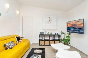 a living room with a yellow couch and two white chairs at IndependentHouse 5TERRE garden , parking in La Spezia
