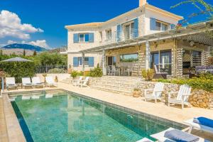 eine Villa mit einem Swimmingpool vor einem Haus in der Unterkunft Mounda Beach Villa in Ratzaklíon