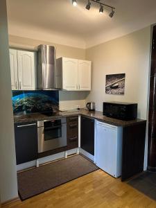 a kitchen with white cabinets and a counter top at Janno apartment in Pärnu