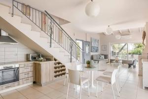 eine Küche und ein Esszimmer mit einem Tisch und einer Treppe in der Unterkunft Mounda Beach Villa in Ratzaklíon