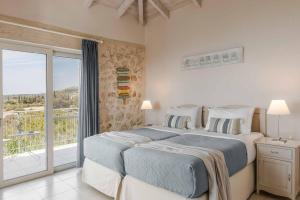 ein Schlafzimmer mit zwei Betten und einem Balkon in der Unterkunft Mounda Beach Villa in Ratzaklíon