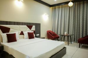 BehrorHotel Highway Prince Kotputli的一间卧室，有一张大床和一把红椅子