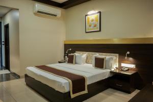BehrorHotel Highway Prince Kotputli的卧室里有一张带木质床头板的大床