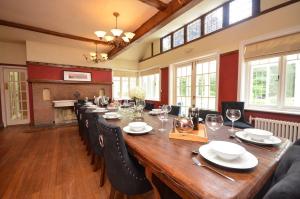 una sala da pranzo con un lungo tavolo in legno e sedie di The Sheriff House - Beautiful large property in Wroxham, perfect for family holidays a Wroxham