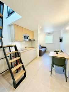 een keuken en een eetkamer met een tafel en een trap bij Les saisonniers in Grimaud