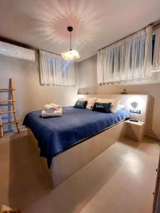 a bedroom with a large bed with a blue blanket at Elements - Air & Water Apartment by Hostandros in Gavrio