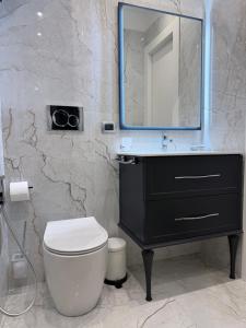 a bathroom with a sink and a toilet and a mirror at Paradise By The Sea in Taormina