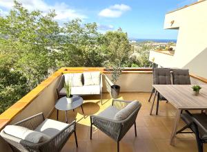 a patio with chairs and tables on a balcony at Hauzify I Apartament Grumet in Sant Feliu de Guixols
