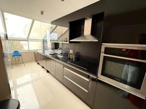 a kitchen with stainless steel appliances and a large window at Hauzify I Apartament Grumet in Sant Feliu de Guixols