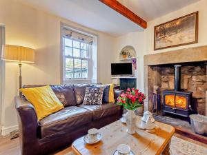 a living room with a leather couch and a fireplace at 2 Bed in Grassington 93941 in Hebden