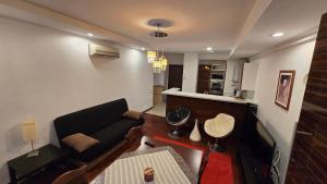 a living room with a couch and a kitchen at AVS Concept Cosmopolis in Ştefăneştii de Sus