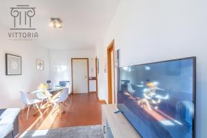 a living room with a large screen tv and a table at Vittoria Apartments Pedemuro 2 in Vicenza +3 photos