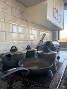 a kitchen counter with pots and pans on a stove at 1 Bedroom Apartment - Flitwick - Contractor Friendly - Tourist Ready - Full Kitchen - WiFi - Smart TV - Sofa Bed - FREE Parking - Ideal for Short or Long Stays in Flitwick