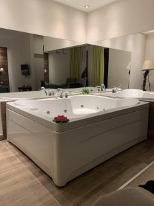 a large bath tub in a bathroom with a large mirror at Jacuzzi In Bedroom Elegance Apartments in Zlatibor