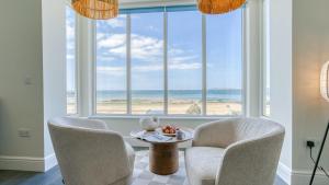 un salon avec deux chaises et une table devant une fenêtre dans l'établissement 3 Beach Terrace, à Rhosneigr