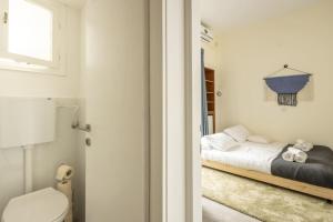 A bed or beds in a room at Eclectic Dreams Rabin Square Apt with Shelter by Sea N' Rent