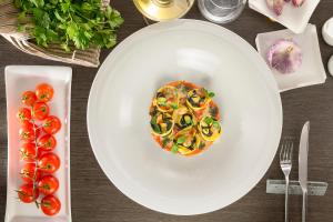 a plate of food on a table with tomatoes at Hotel Indigo Rome - St. George by IHG in Rome