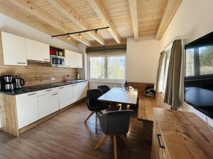 a kitchen with white cabinets and a table and chairs at Mari's Landhaus in Biberwier