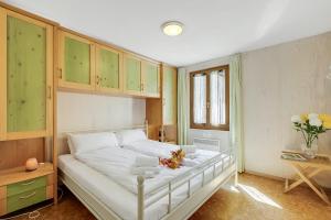 a bedroom with a large white bed with green cabinets at Casa Andy 1 Val Lavizzara - Happy Rentals in Al Piano